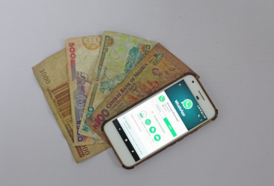 Naira notes beside a mobile-money app